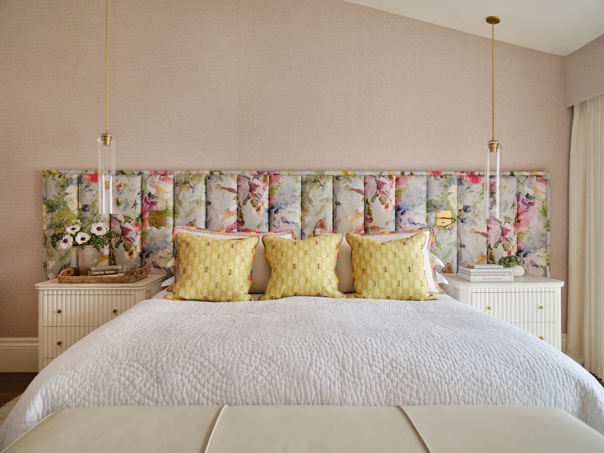 Master bedroom with calm, layered textiles and bedside lighting controls, combining luxury and practical design.